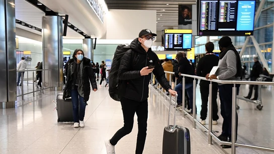 Viajeros llegando a un aeropuerto de Reino Unido Viajeros llegando a un aeropuerto de Reino Unido
