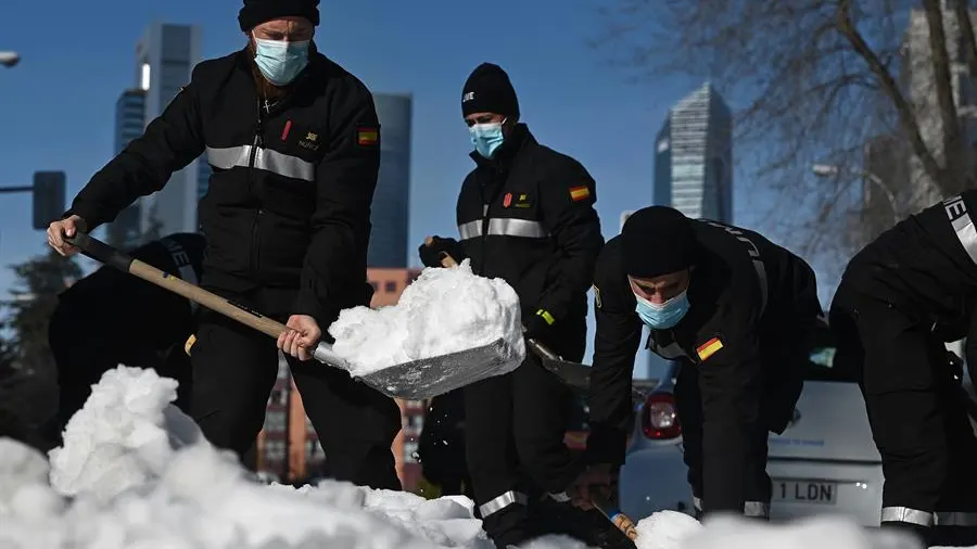  Varios efectivos limpian una calle tras las fuertes nevadas causadas por el temporal Filomena en Madrid.