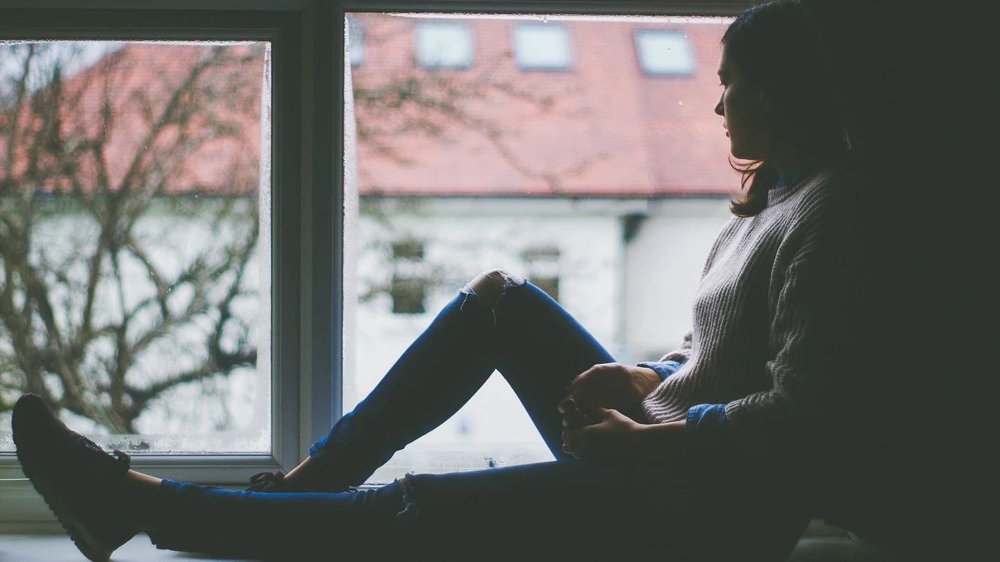 ¿Qué dice la ciencia sobre el Blue Monday? Mujer mirando por una ventana