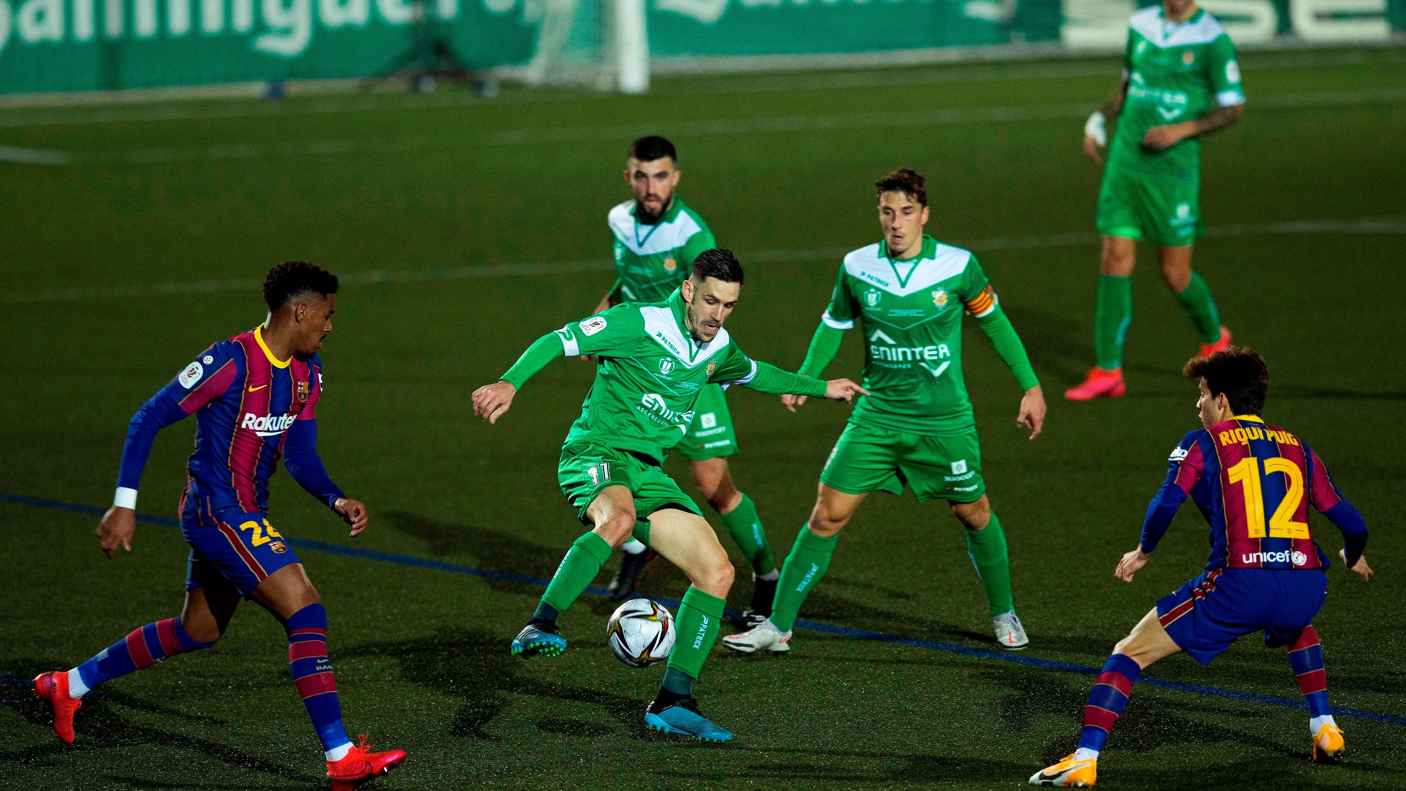 Puja por el balón durante el Cornellà-Barça