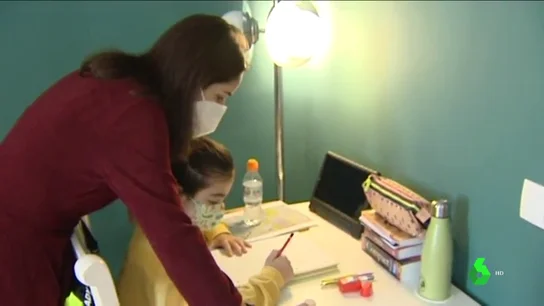 Imagen de una niña con patologías previas haciendo los deberes con su madre Imagen de una niña con patologías previas haciendo los deberes con su madre