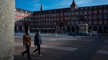 Personas con mascarilla caminan por la Plaza Mayor de Madrid