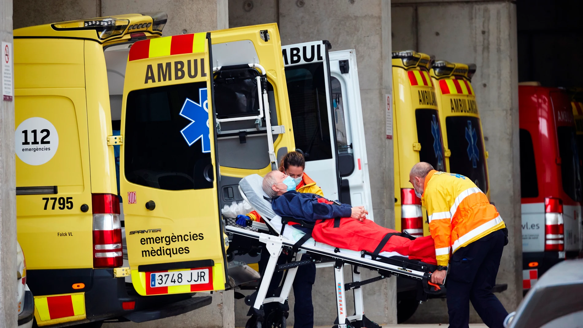 Dos técnicos de emergencias trasladan a un paciente en la zona de urgencias del Hospital Universitario de Bellvitge 