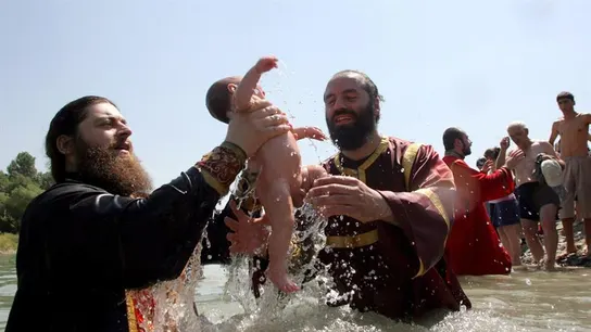 Dos sacerdotes ortodoxos georgianos sostienen un niño durante una ceremonia de Bautismo Dos sacerdotes ortodoxos georgianos sostienen un niño durante una ceremonia de Bautismo