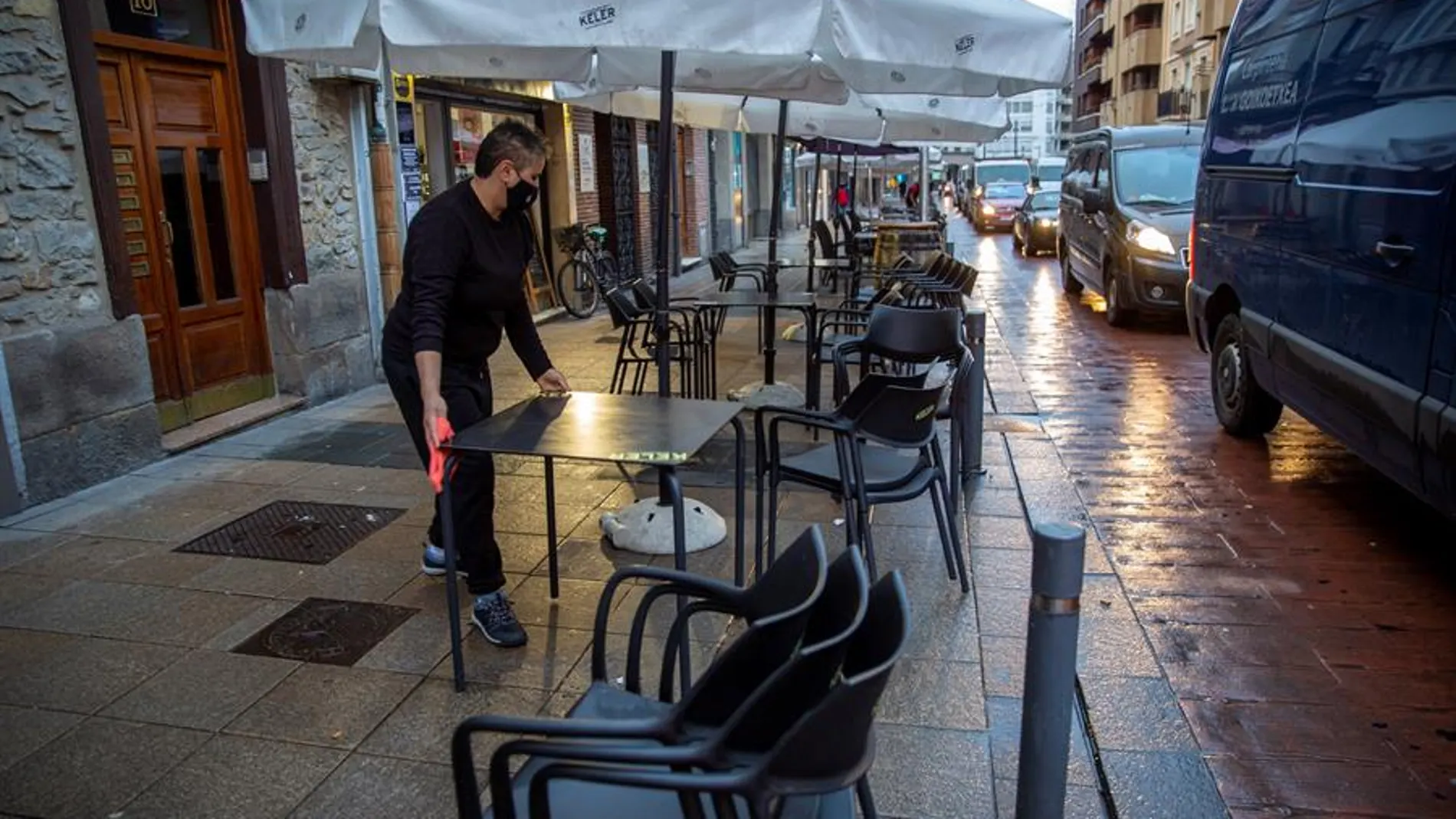 Un camarero monta la terraza de su bar en Vitoria después de que se levante su cierre.