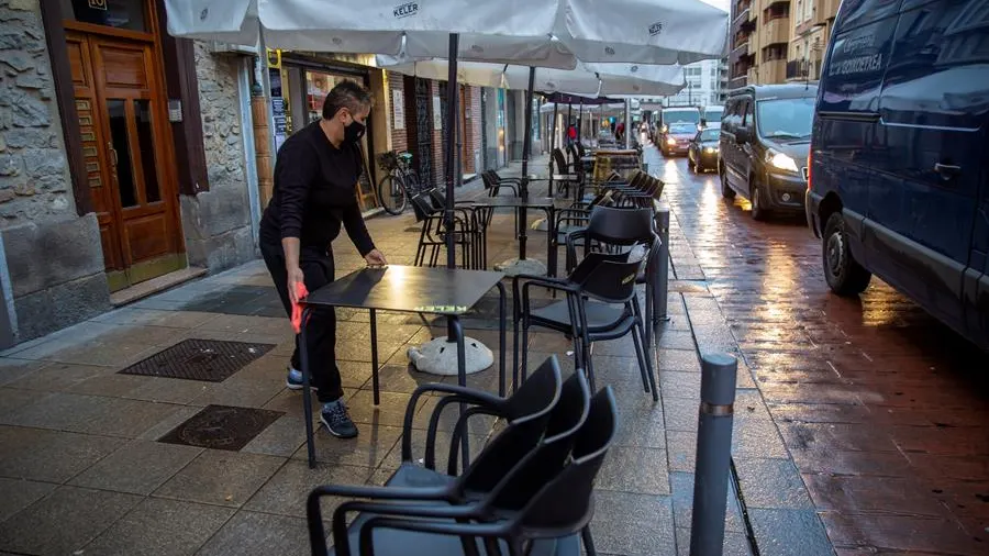 Un camarero monta la terraza de su bar en Vitoria después de que se levante su cierre.