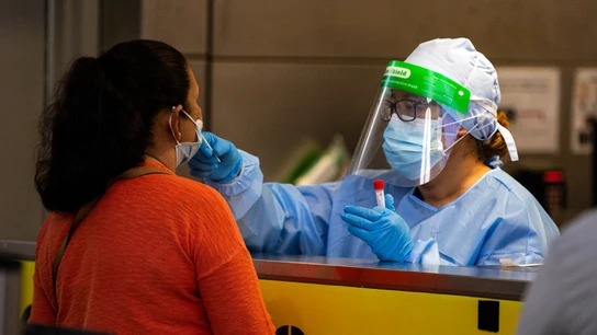 Una profesional sanitaria realiza una prueba PCR a una paciente Una profesional sanitaria realiza una prueba PCR a una paciente