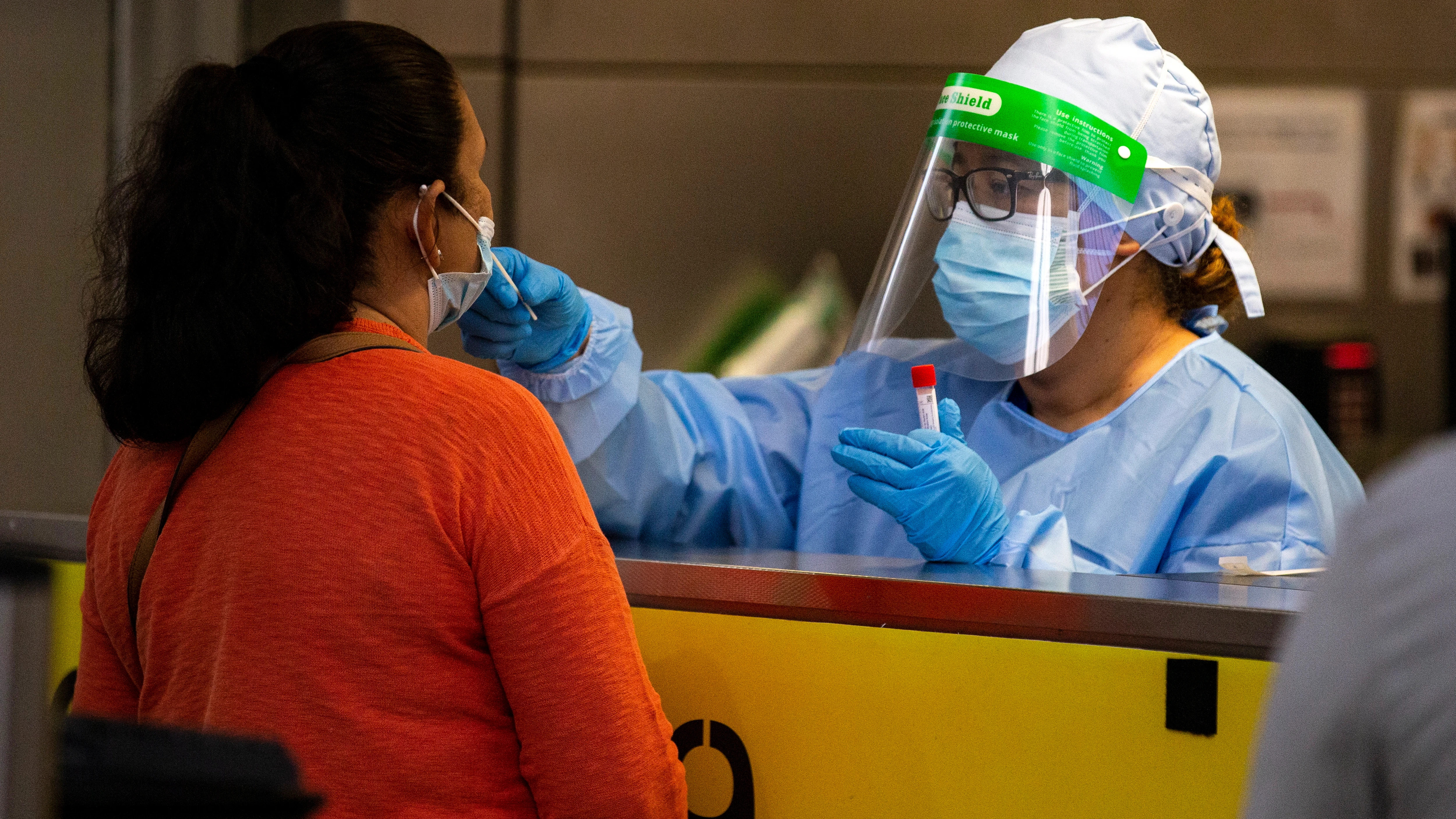 Una profesional sanitaria realiza una prueba PCR a una paciente