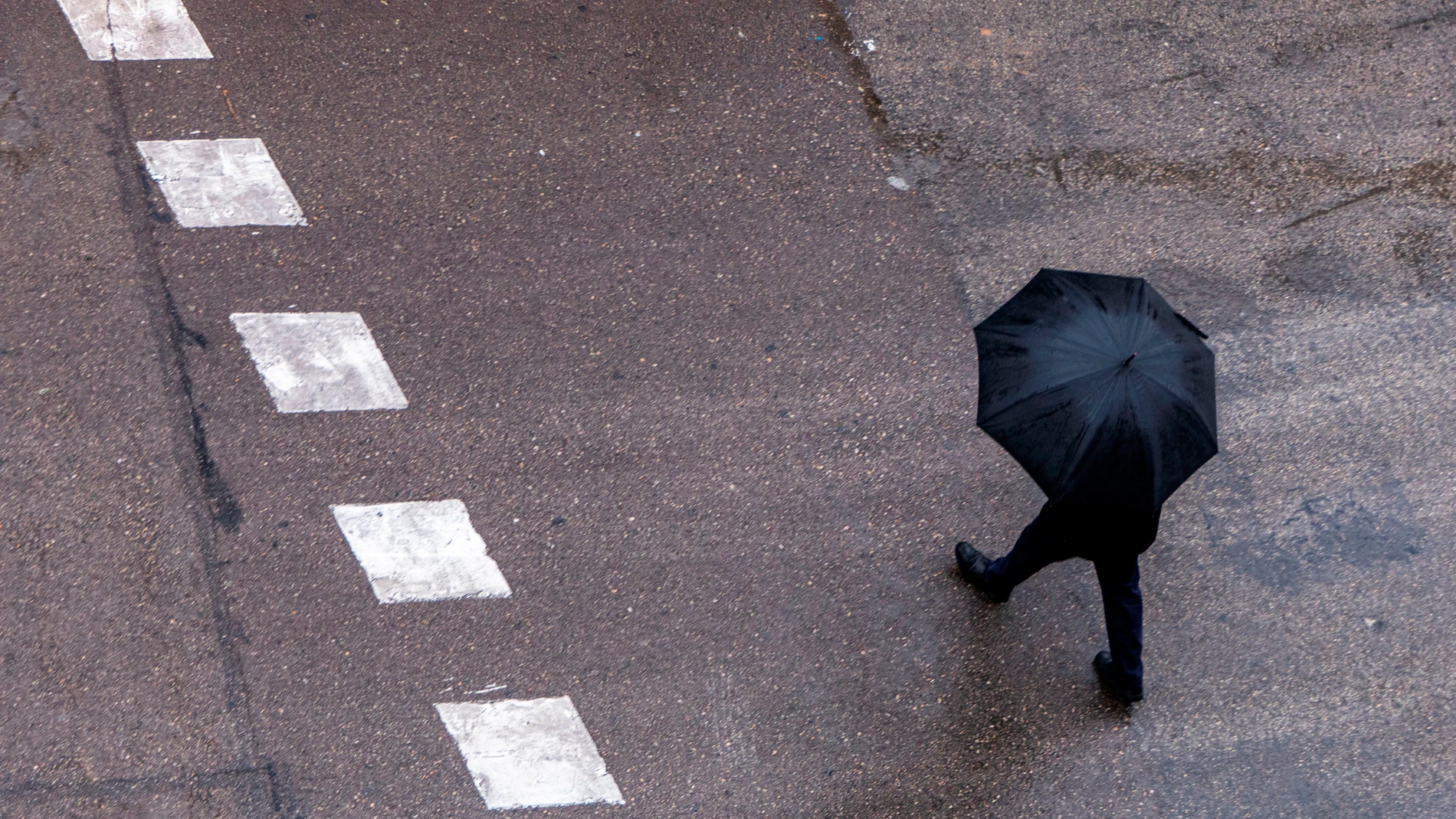 Un hombre pasea con un paraguas