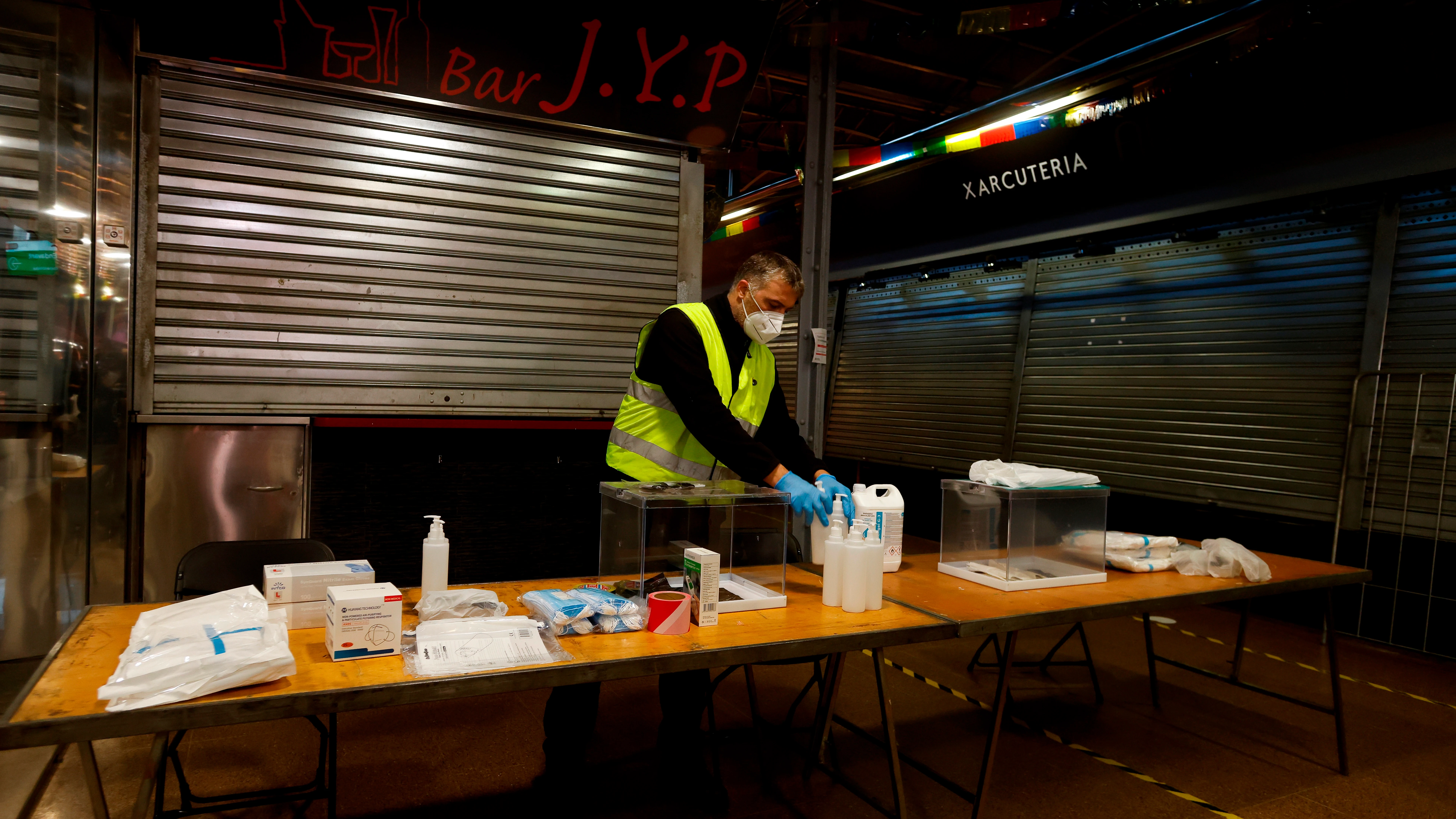 Un operario prepara una mesa electoral de cara a las elecciones en Cataluña del 14 de febrero