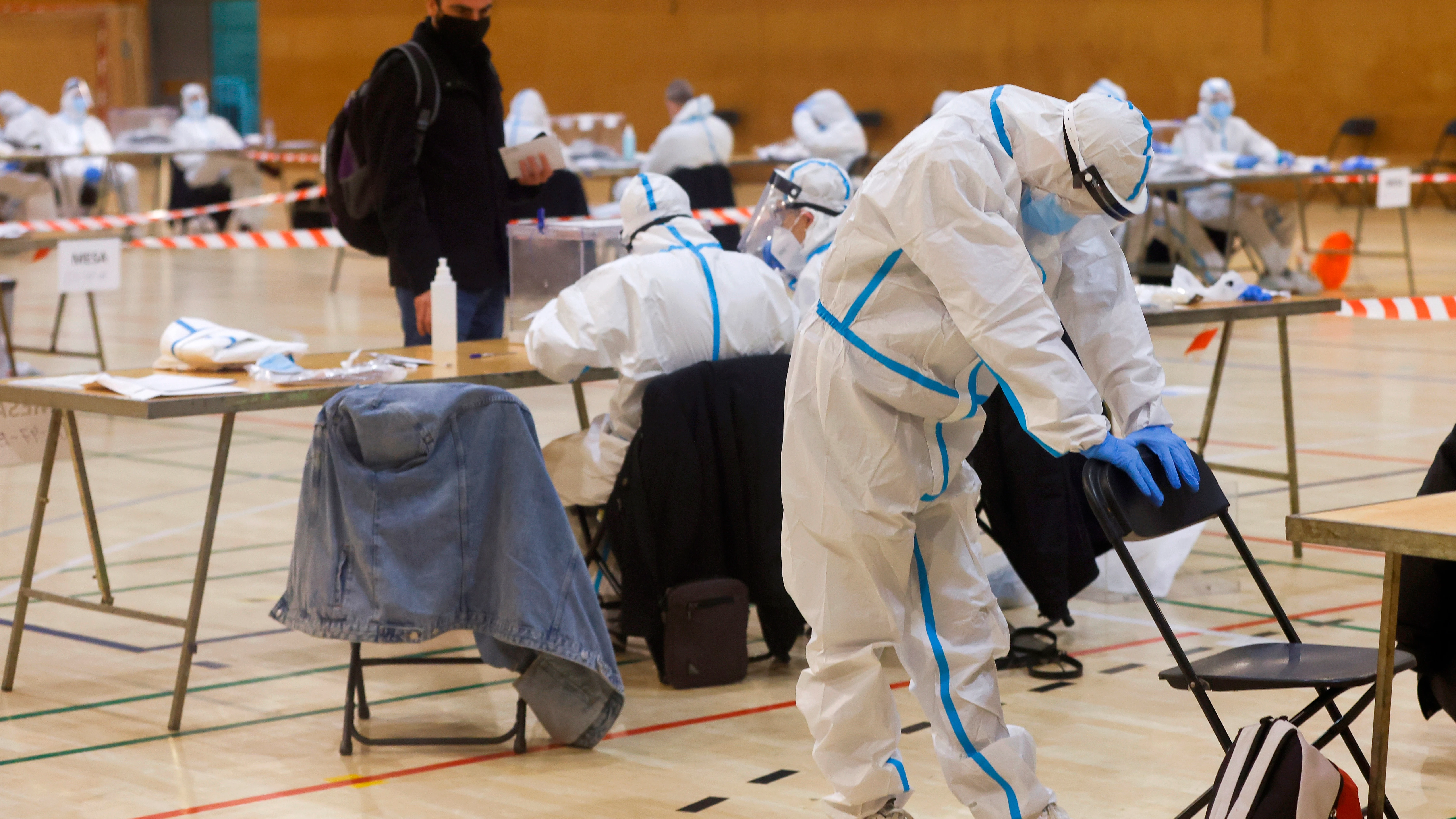  Varias personas vestidas con equipos de protección individual (EPI) en las elecciones catalanas