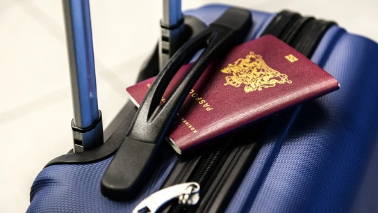 Imagen de archivo de un pasaporte y una maleta Imagen de archivo de un pasaporte y una maleta