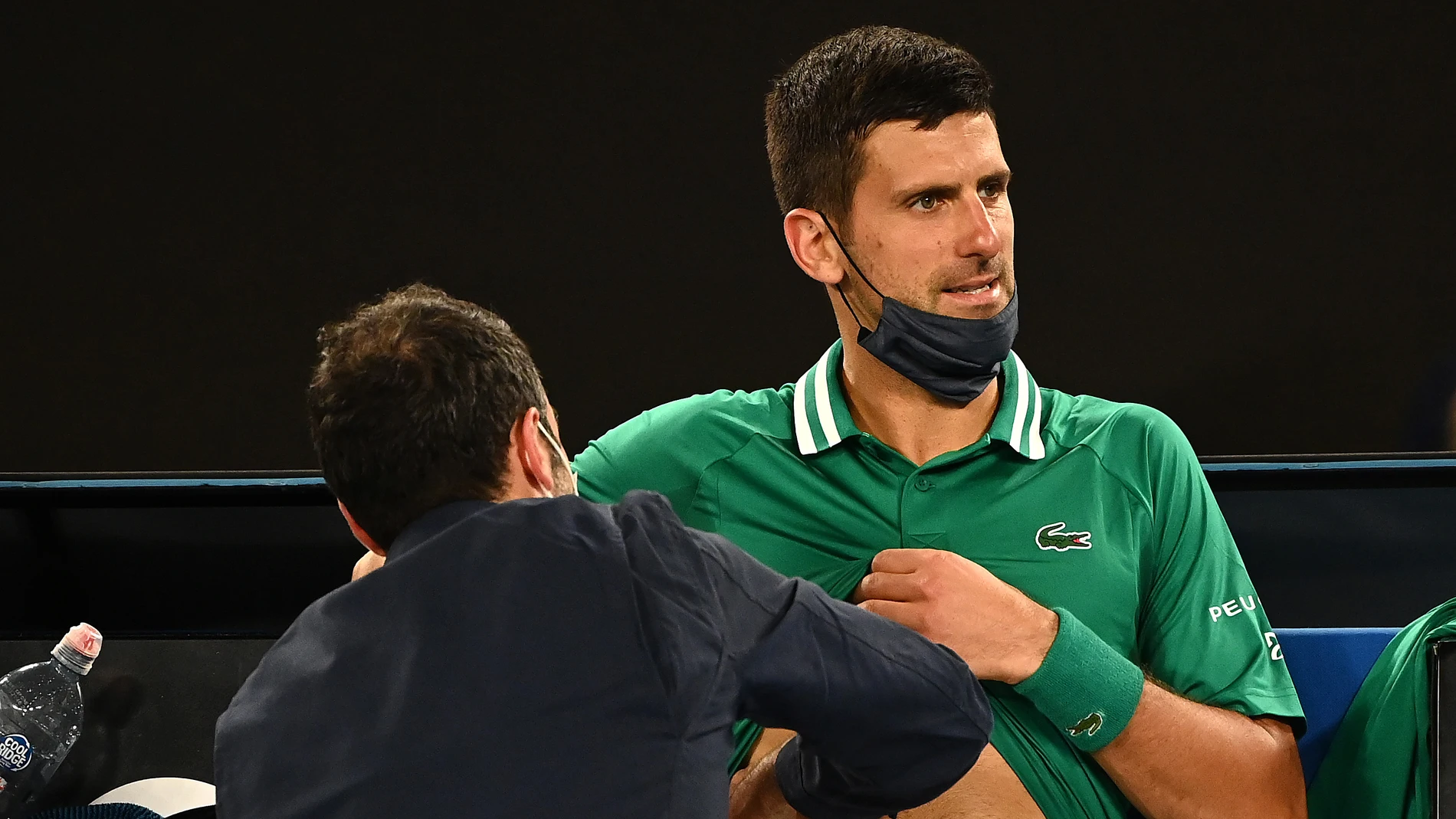 Un médico atiende a Novak Djokovic durante el Open de Australia