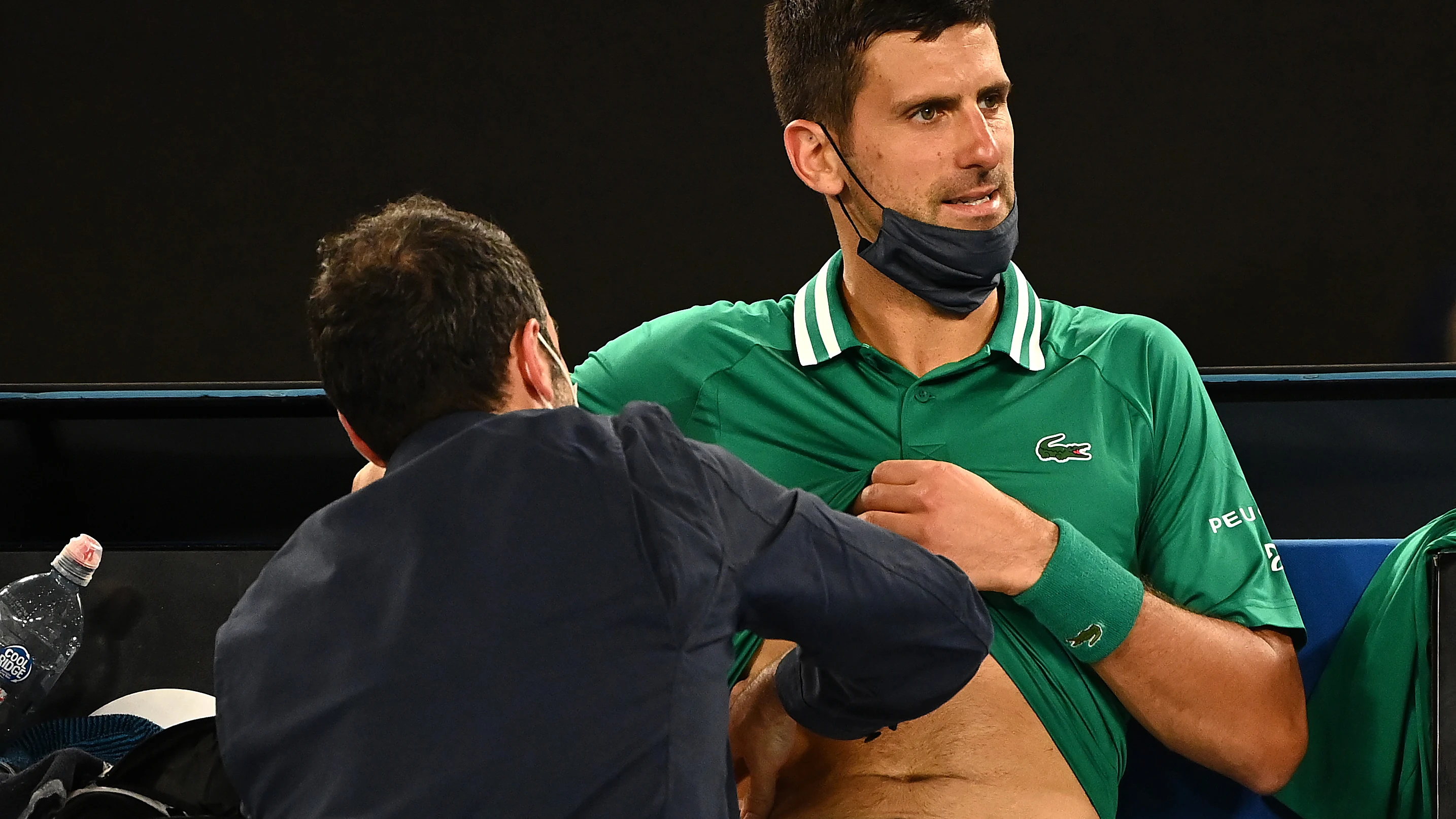 Un médico atiende a Novak Djokovic durante el Open de Australia