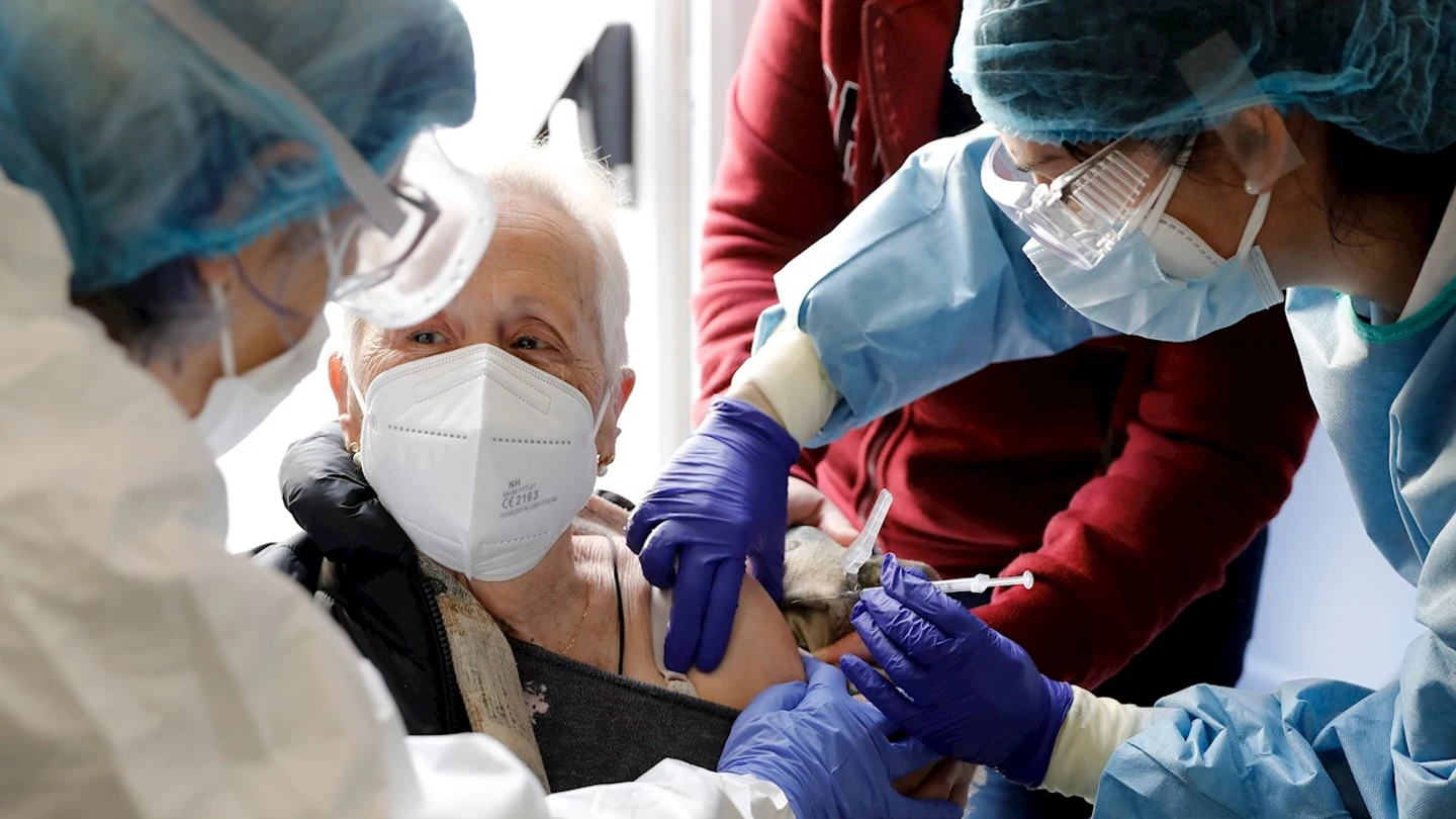Dos sanitarias vacunan a una anciana en una residencia Dos sanitarias vacunan a una anciana en una residencia