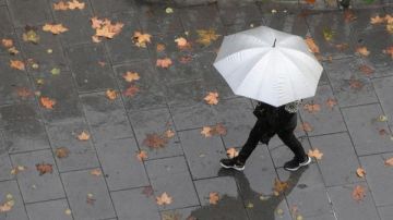 Imagen de archivo de una persona caminando bajo la lluvia