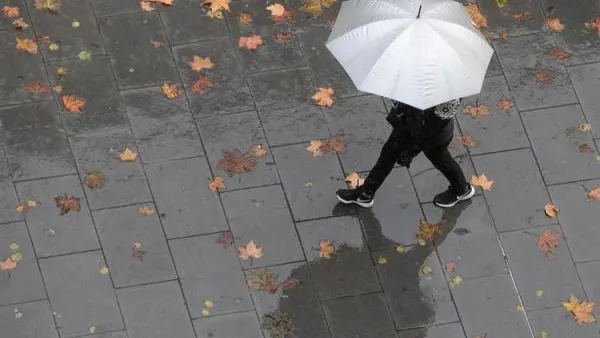 Imagen de archivo de una persona caminando bajo la lluvia