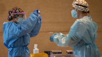 Un trabajador sanitario sostiene una probeta en un dispositivo de cribado masivo de antígenos en Alcorcón