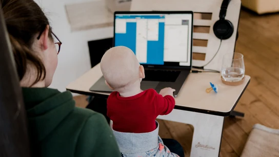 Imagen de archivo de una madre teletrabajando con su bebé Imagen de archivo de una madre teletrabajando con su bebé