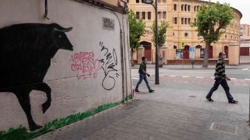 Dos hombres caminan junto a la plaza de toros de la Condomina de Murcia