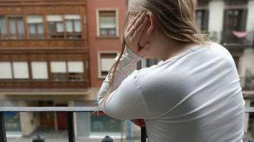 Imagen de una niña asomada al balcón durante el confinamiento por el estado de alerta