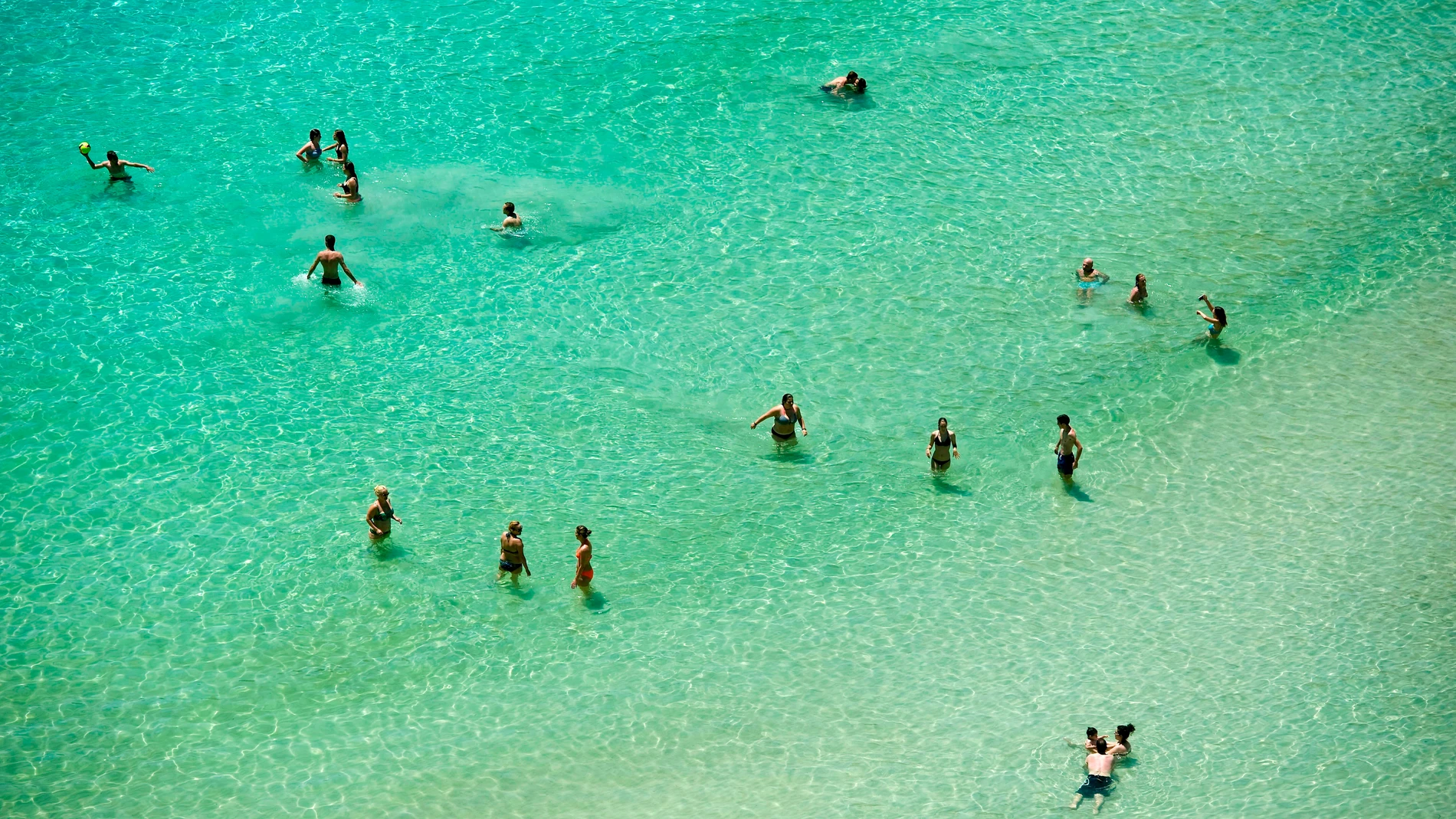 Varias personas se bañan en la playa de Cala en Porter (Alaior), en la costa sur de Menorca.