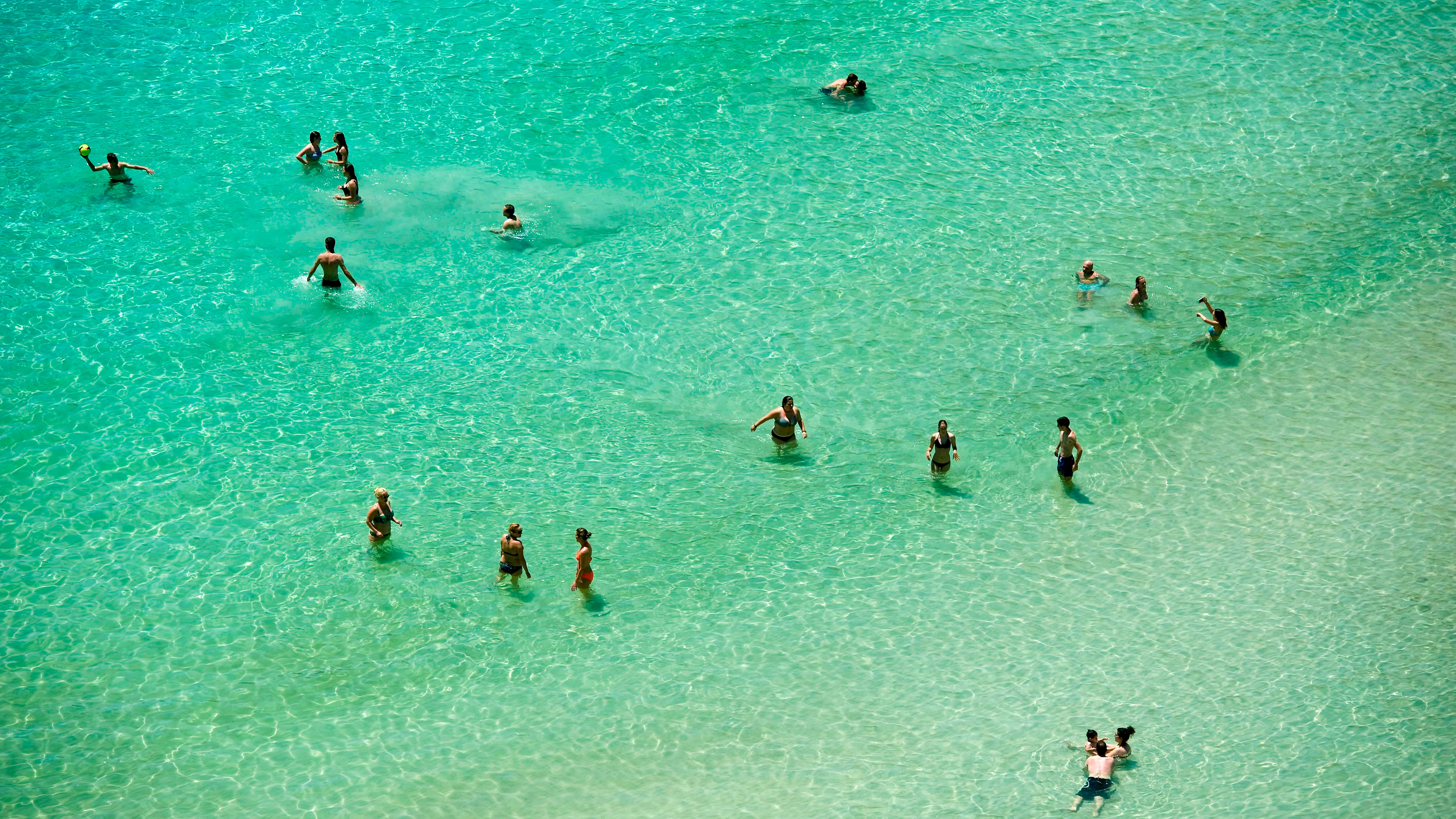 Varias personas se bañan en la playa de Cala en Porter (Alaior), en la costa sur de Menorca.