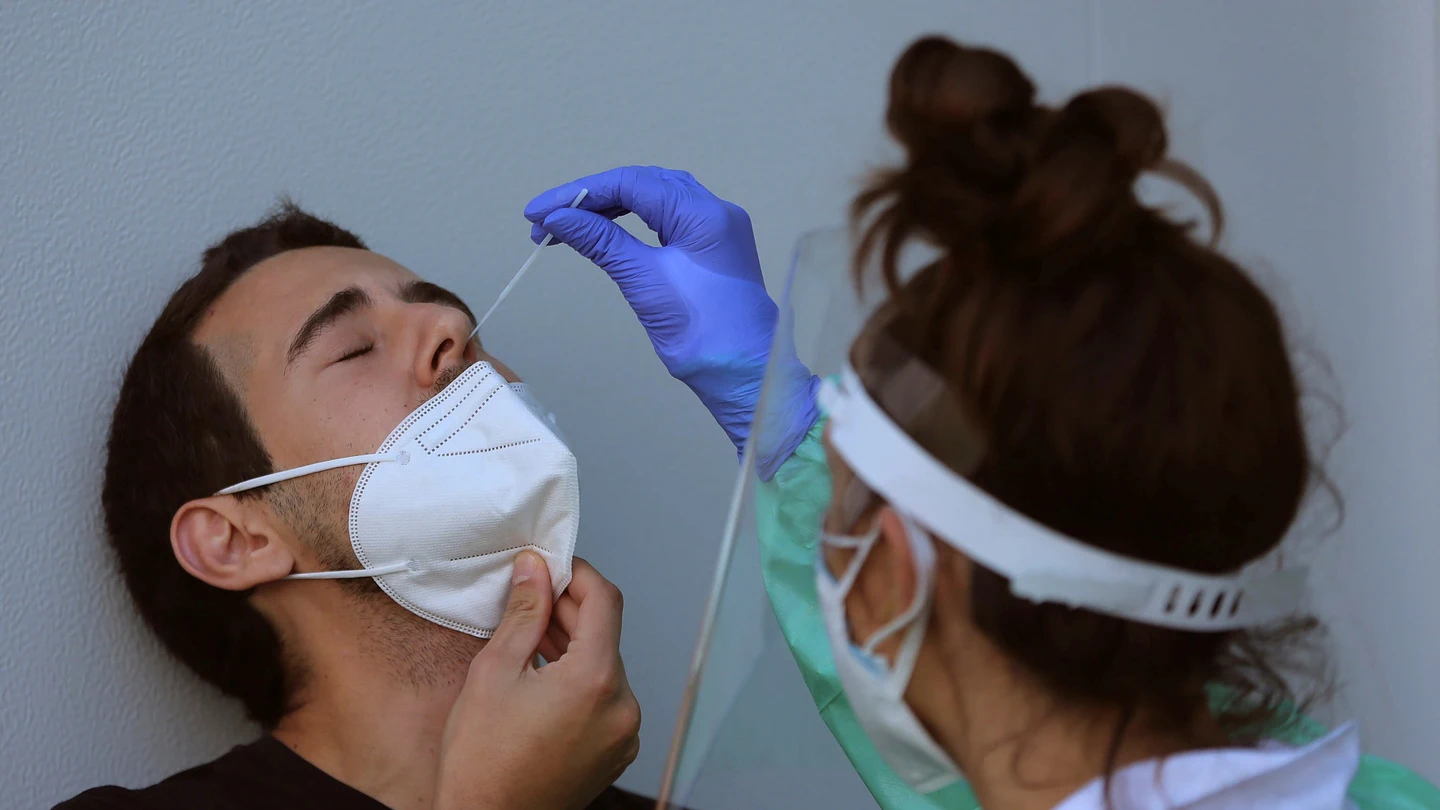 Personal sanitario realizando una PCR a una persona Personal sanitario realizando una PCR a una persona