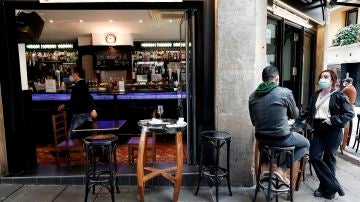  Dos personas toman un aperitivo en el exterior de un bar de Pamplona