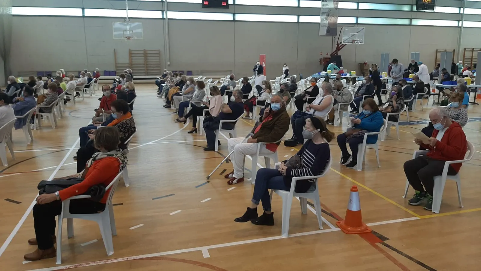 Ciudadanos en la zona post-vacunación del pabellón deportivo El Toscar de Elche.