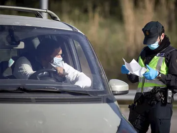 Una imagen de archivo en la que un hombre muestra los papeles de su coche a un agente Una imagen de archivo en la que un hombre muestra los papeles de su coche a un agente