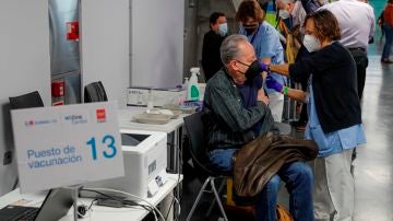 Una persona recibe una dosis de vacuna en el Wizink Center de Madrid