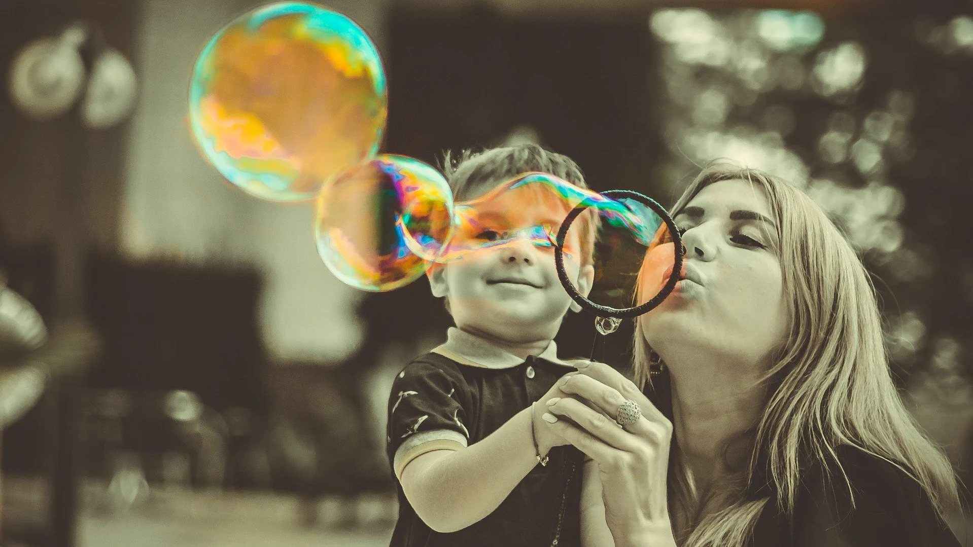 Una madre y su hijo juegan con pompas de jabón