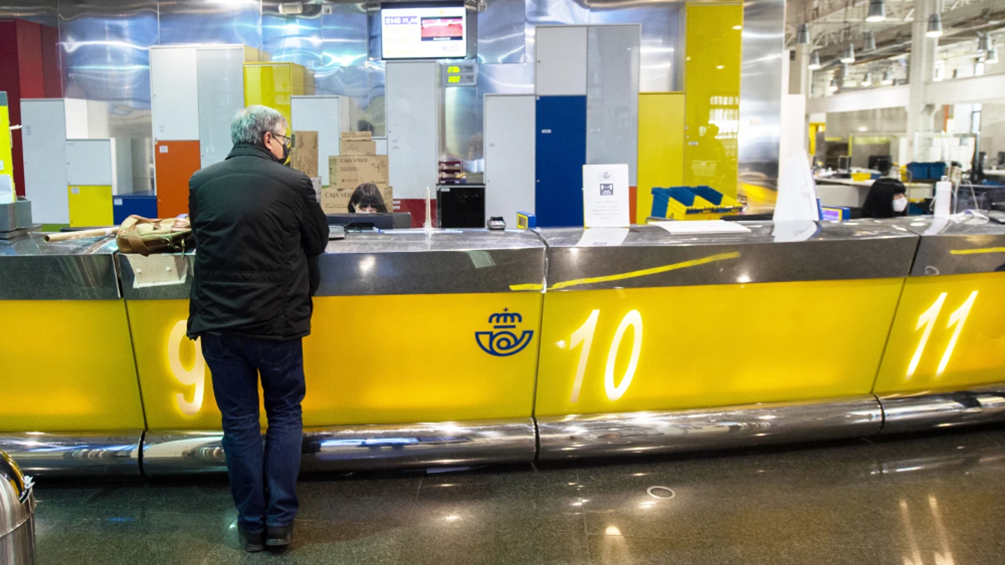Un hombre esperando en una oficina de Correos Un hombre esperando en una oficina de Correos