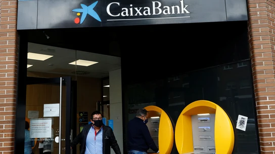 Varias personas operan en una sucursal de Caixabank Varias personas operan en una sucursal de Caixabank