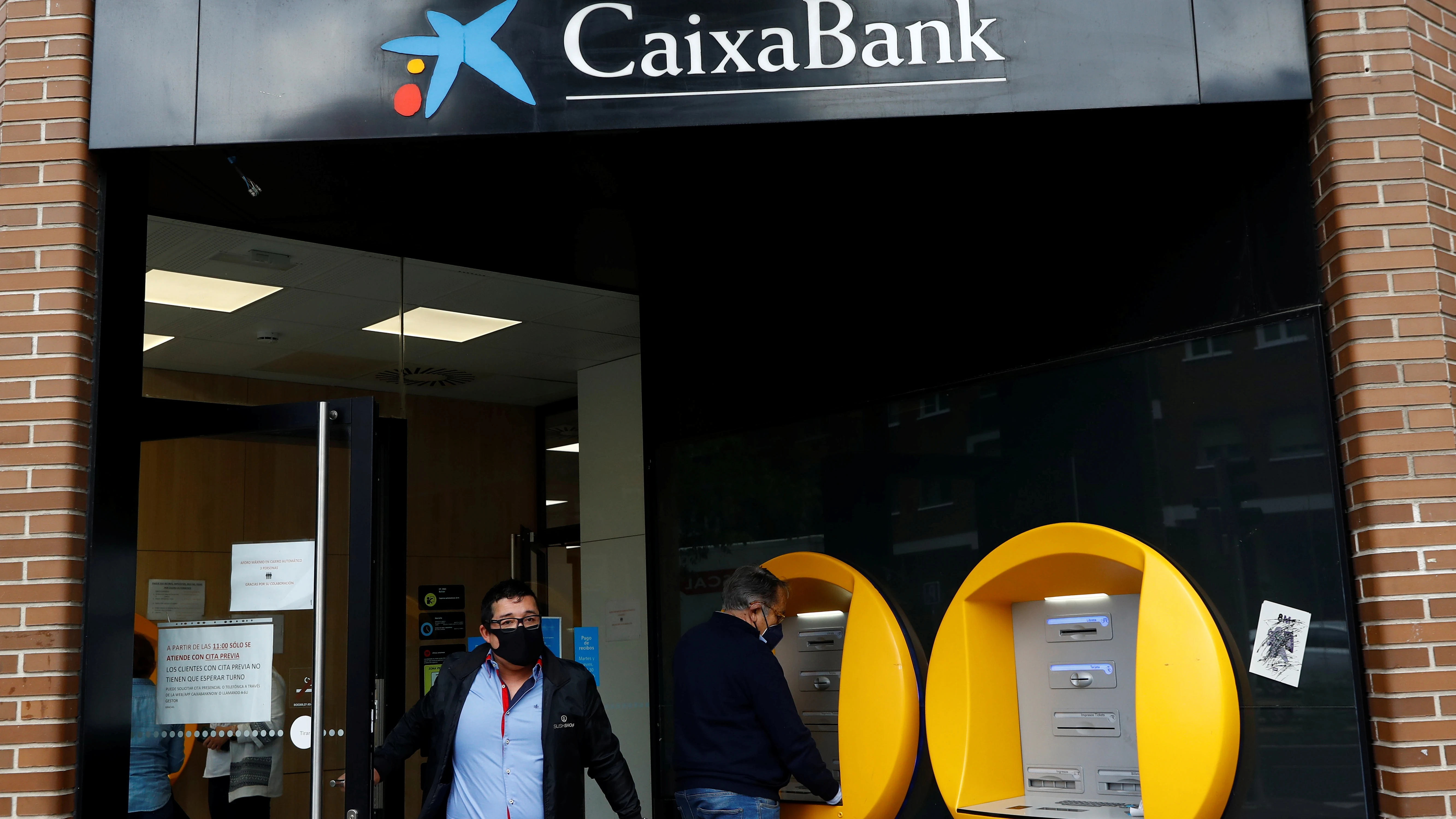 Varias personas operan en una sucursal de Caixabank