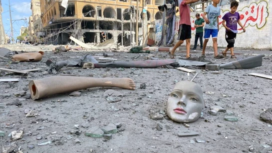 Partes de un maniquí roto yacen este miércoles en el suelo cerca de una torre que fue alcanzada por ataques aéreos israelíes en Gaza Gaza