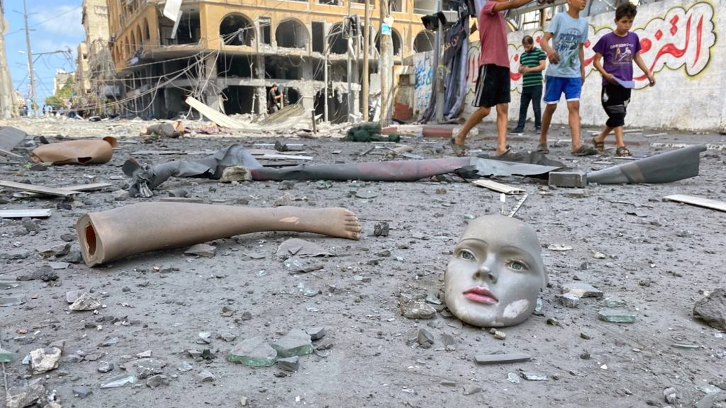 Partes de un maniquí roto yacen este miércoles en el suelo cerca de una torre que fue alcanzada por ataques aéreos israelíes en Gaza Gaza