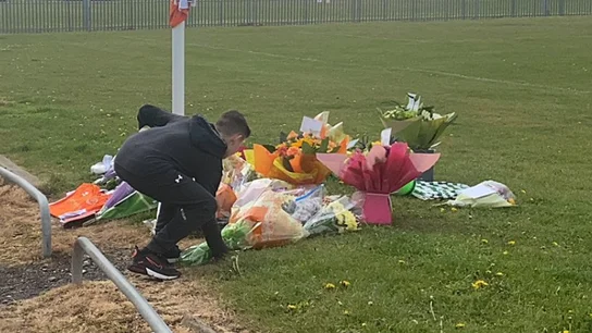 Niño depositando flores en el lugar donde falleció Jordan Banks Niño depositando flores en el lugar donde falleció Jordan Banks