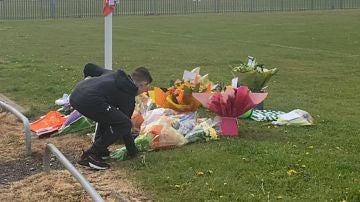 Niño depositando flores en el lugar donde falleció Jordan Banks