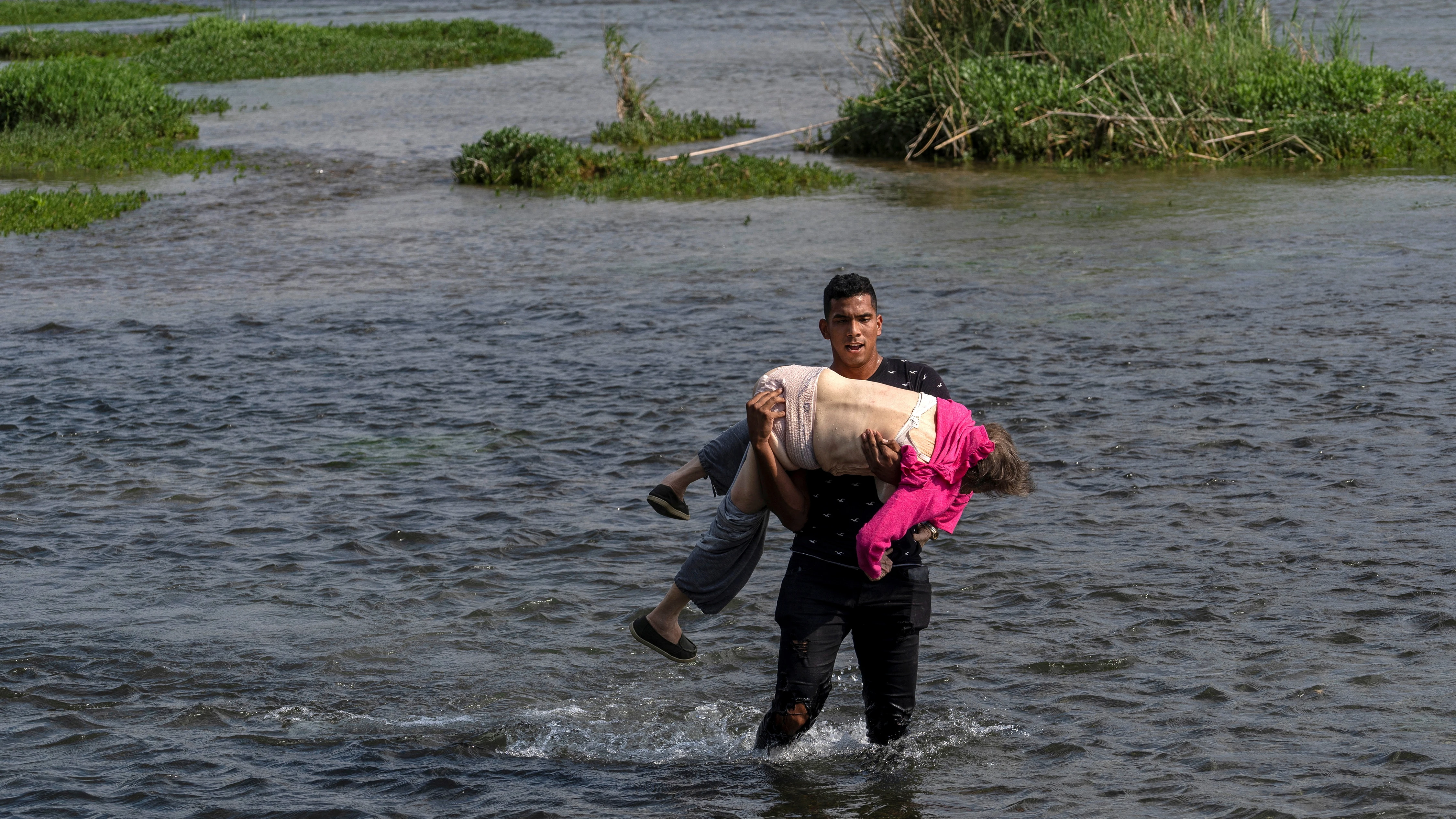 Sobrecogedora imagen de una mujer venezolana de 80 años que cruzó el Río Bravo en los brazos de un joven