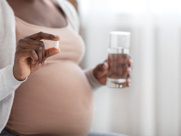 mujer embarazada con un paracetamol en la mano