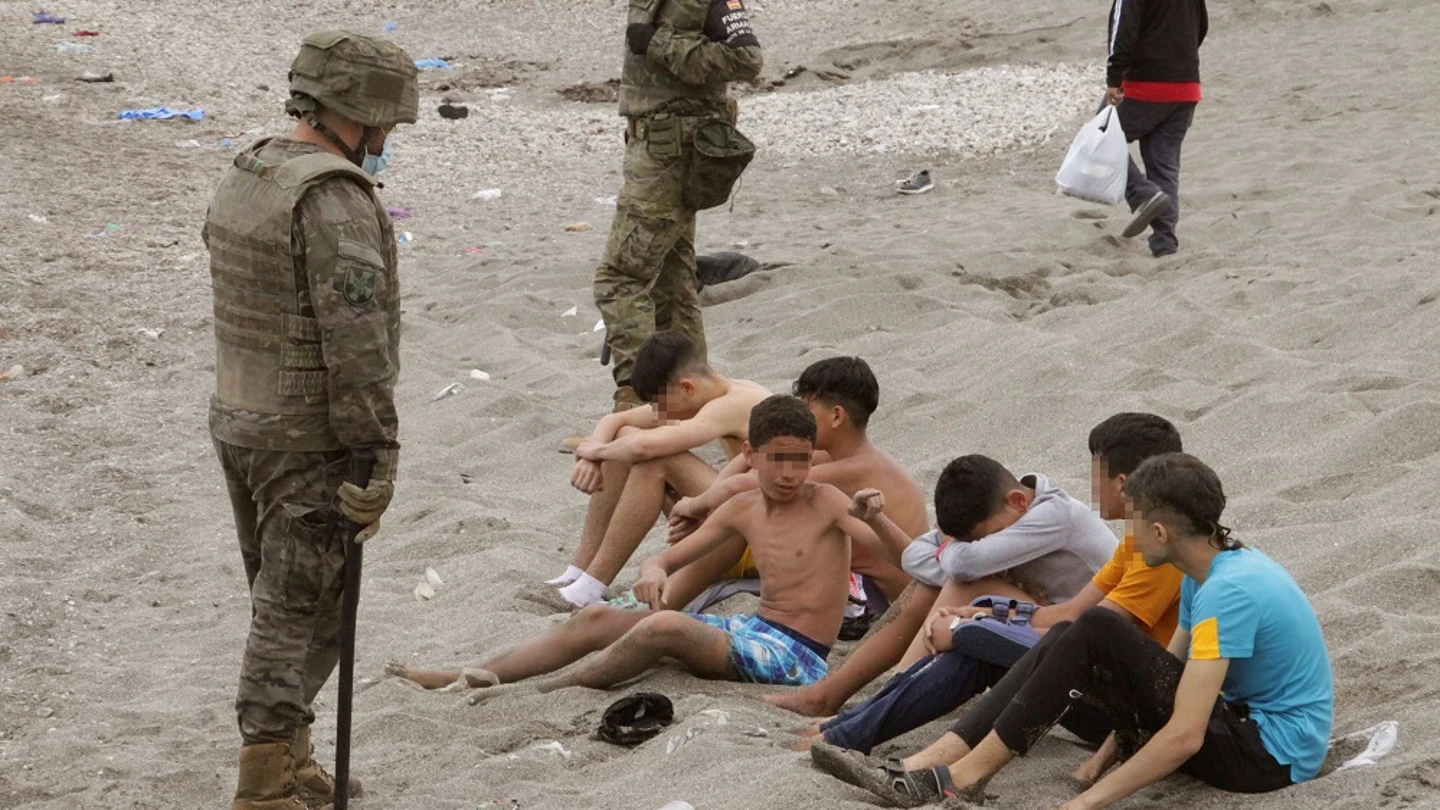 Miembros del Ejército de Tierra vigilan a un grupo de inmigrantes menores tras su entrada en Ceuta Miembros del Ejército de Tierra vigilan a un grupo de inmigrantes menores tras su entrada en Ceuta