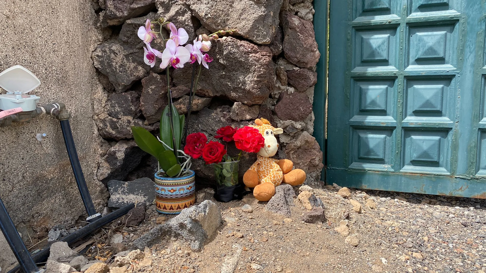 Flores y un peluche en la puerta de la casa de Gimeno
