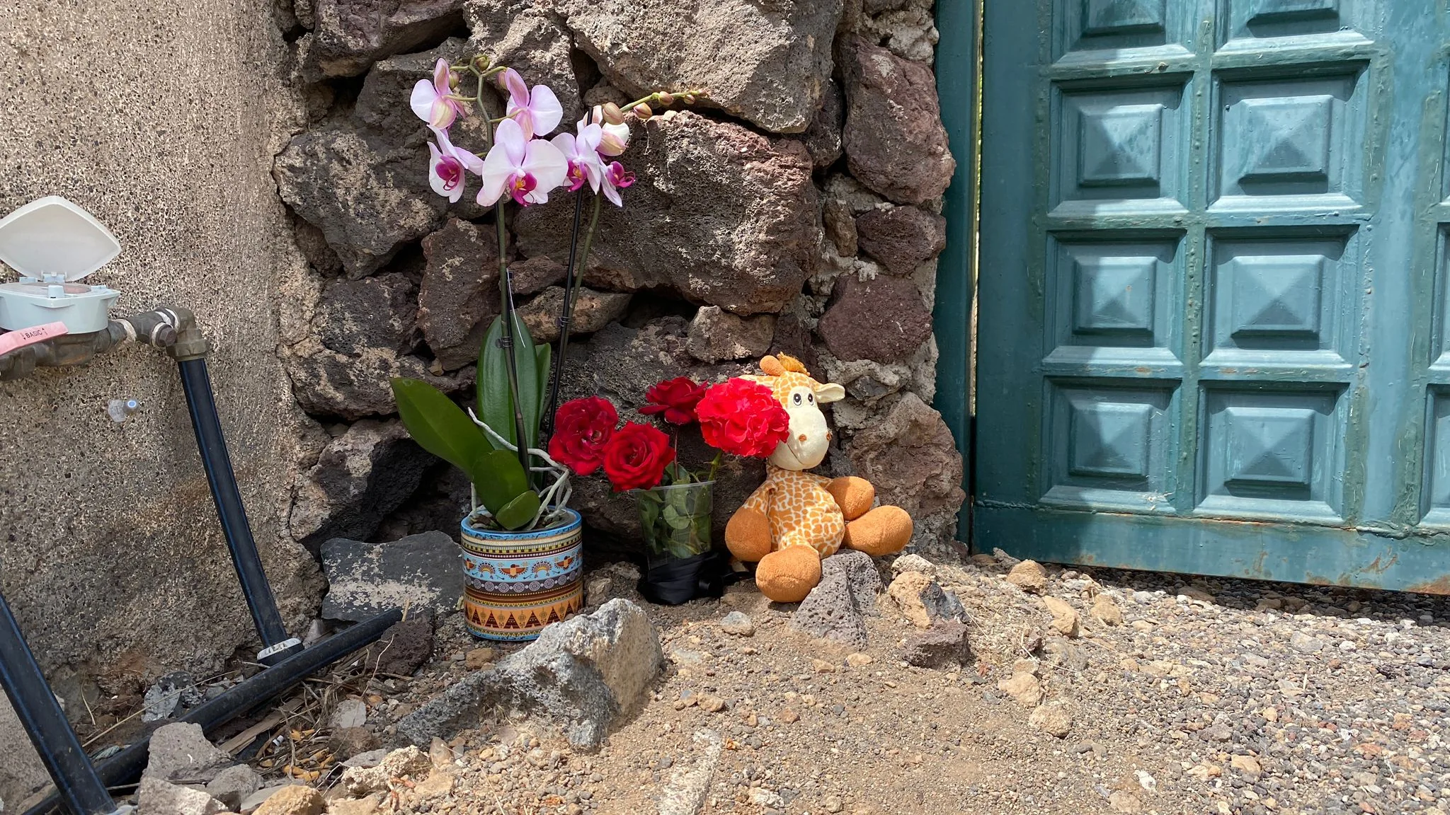 Flores y un peluche en la puerta de la casa de Gimeno