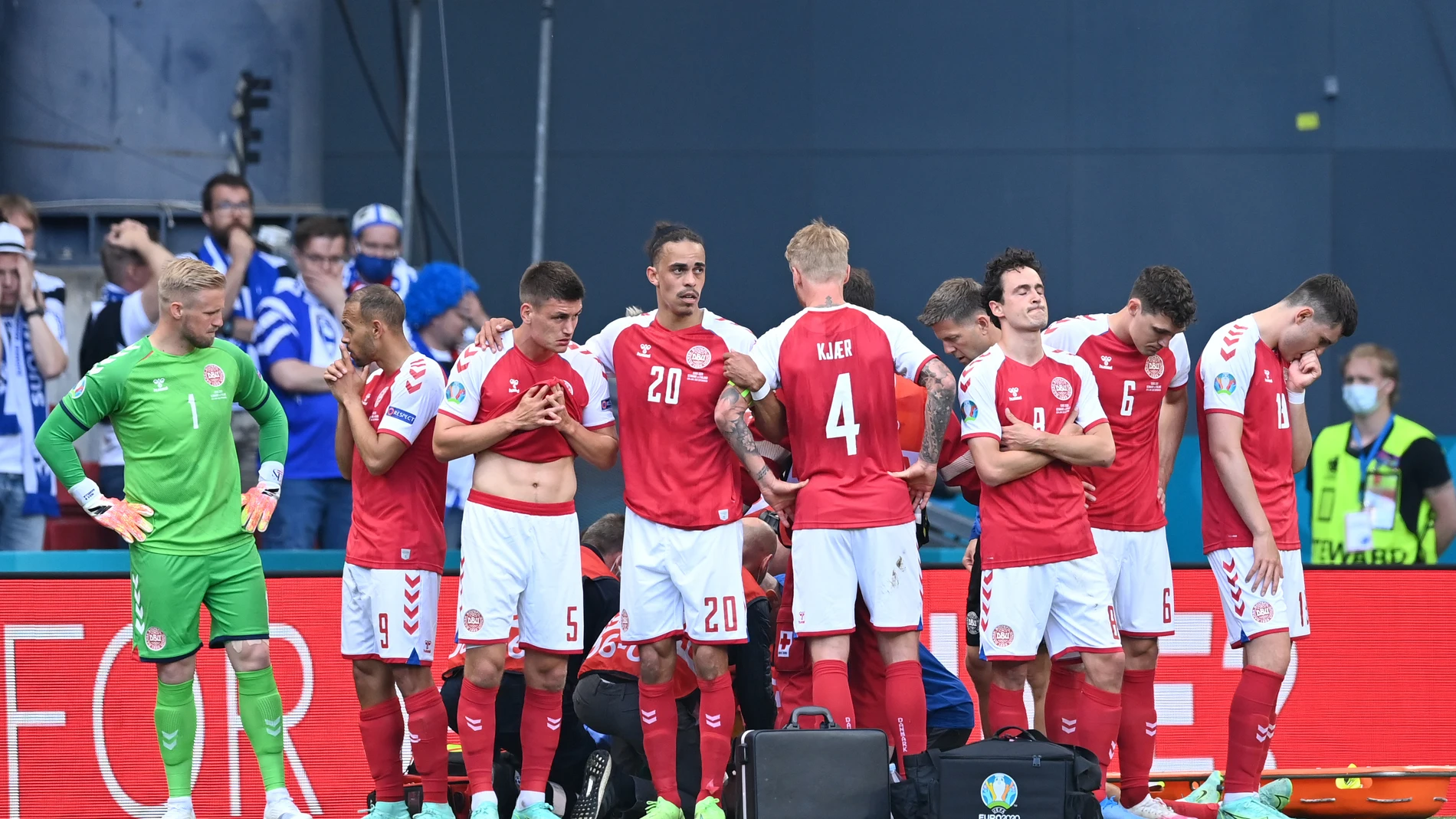 Jugadores de la selección danesa se colocan alrededor de Eriksen mientras está siendo atendido