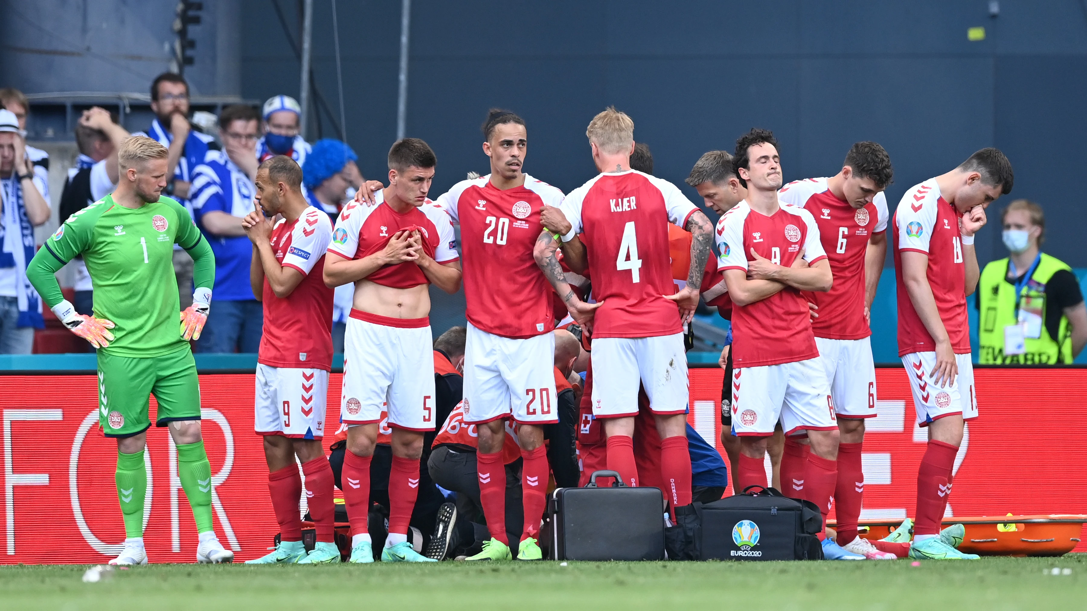 Jugadores de la selección danesa se colocan alrededor de Eriksen mientras está siendo atendido