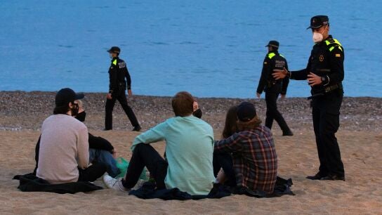 Un grupo de personas sentado en una playa de Barcelona