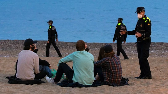 Un grupo de personas sentado en una playa de Barcelona Un grupo de personas sentado en una playa de Barcelona