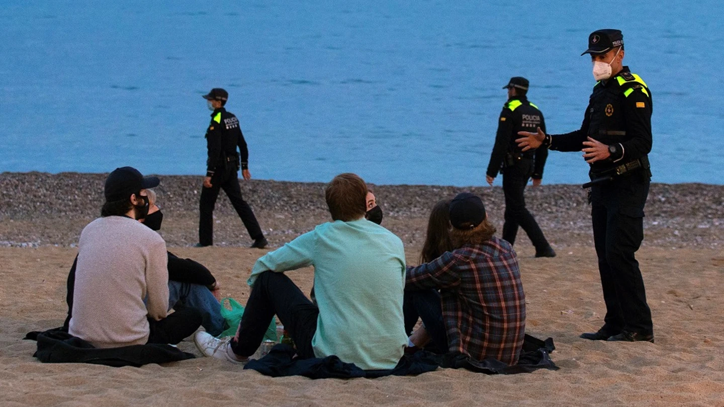 Un grupo de personas sentado en una playa de Barcelona Un grupo de personas sentado en una playa de Barcelona